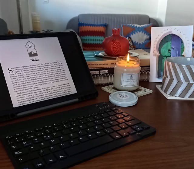 La novela en una tableta junto a una vela